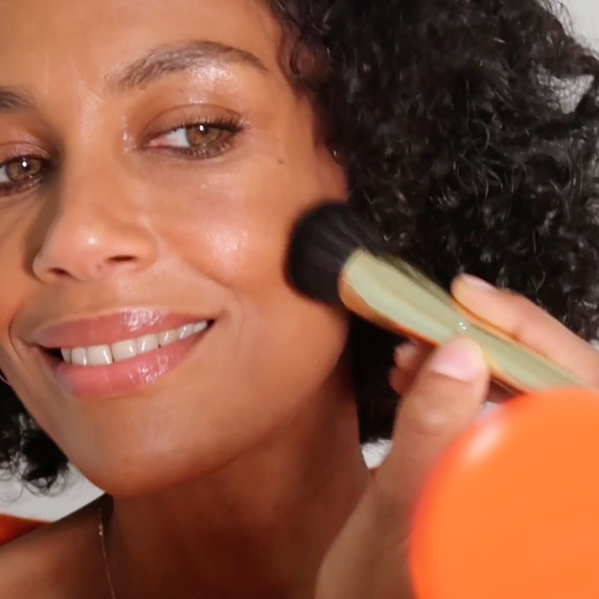 model applying Just Like Paradise bronzer with Dual Contour Brush